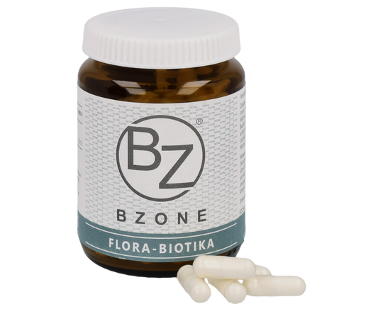 Braunes Glasgefäß mit weißem Deckel, beschriftet mit dem BZONE Flora Biotika Etikett, neben dem Braunglas liegen einige weiße Flora Biotika Probiotikum Kapseln.